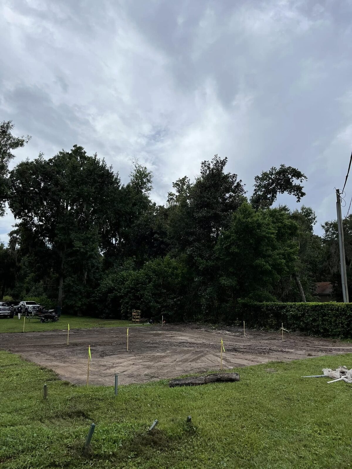 Same site after demolition with the structure removed, debris hauled, and lot graded and staked out for new construction