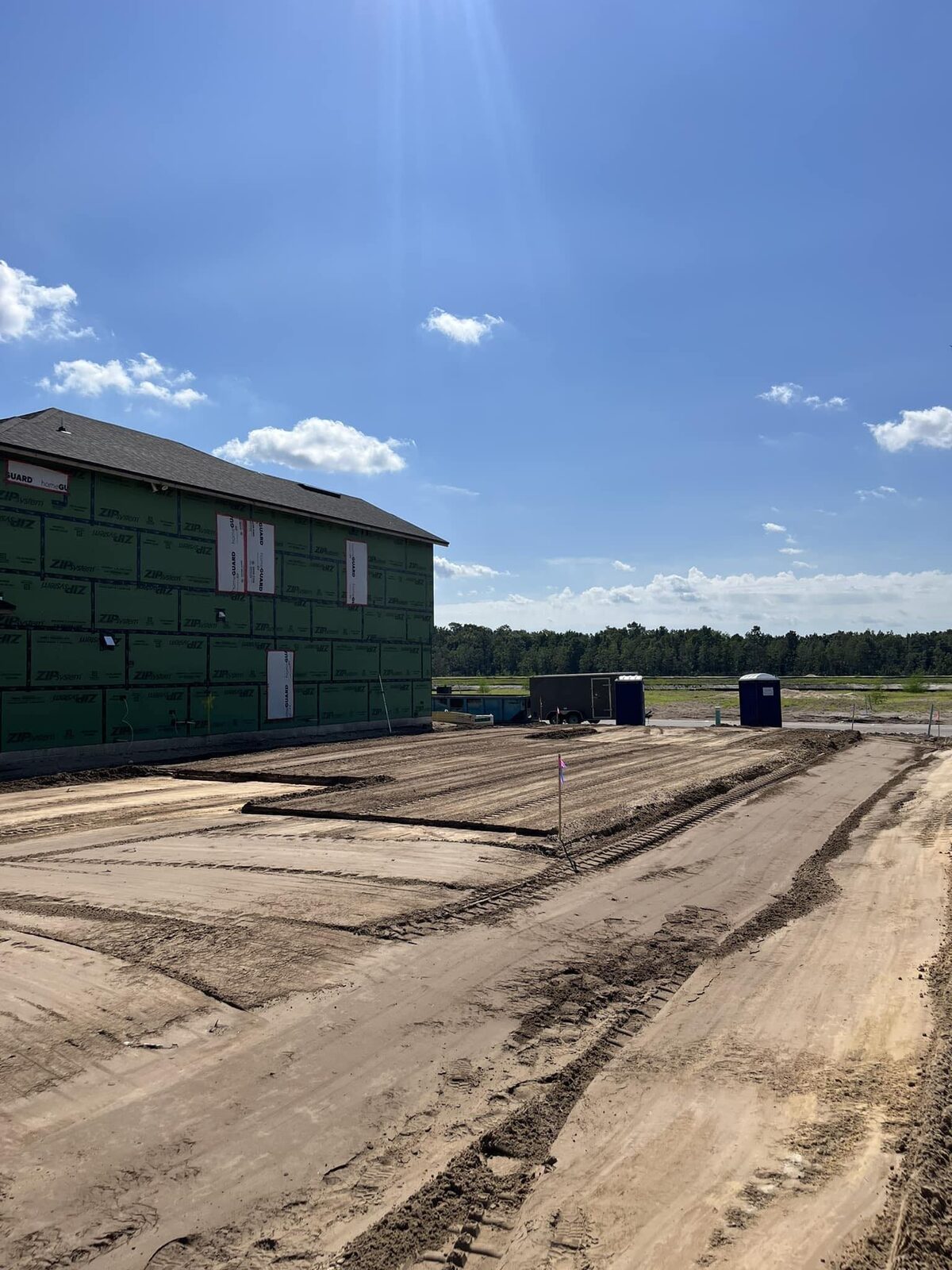 Freshly graded residential lot next to a new home under construction in the Jacksonville metro